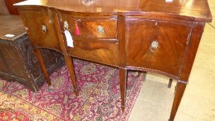 A Georgian style mahogany sideboard the serpentine front with drawers and cupboard on tapered