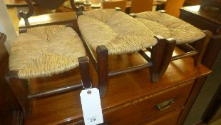 A set of three fruitwood and rush seat stools
