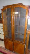 A C20th mahogany display cabinet having bar and glazed panels above cupboards