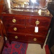 A Georgian mahogany chest having two short above two long drawers with oval brass handles on bracket