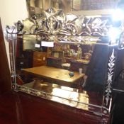 A Venetian wall mirror with foliate crest above rectangular plate