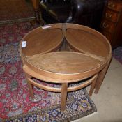A Danish design teak nest of tables the circular top above three oval tables