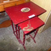 A red lacquer Regency style nest of two tables and a Chinoiserie circular table