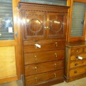 A circa 1920's mahogany tall cabinet with cupboards above an arrangement of drawers