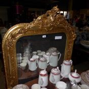 A gilted wall hanging mirror with carved crest