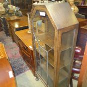 A C20th oak display cabinet with shelves on bun feet