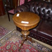 A Victorian walnut trumpet form work table the hinged top above faceted column on tripod base