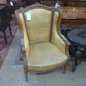 A pair of French bergere chairs with yellow foliate upholstery on carved support