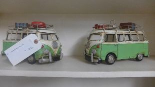 A pair of painted metal campervans