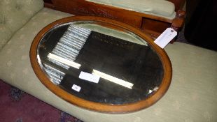 An oak oval mirror with bevelled plate