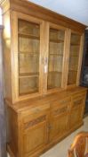 A large Victorian oak bookcase the moulded cornice above triple glazed panel drawers and cupboards