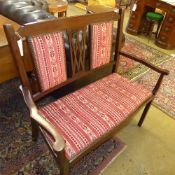 An Edwardian inlaid mahogany pierced and back settee on slender supports
