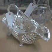 A silver plated wine bottle cradle