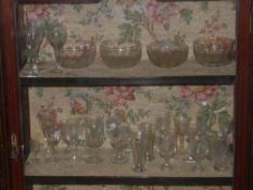 A collection of engraving and cut glass drinking glasses and four finger bowls