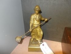 A heavy gilded cast iron figure of a foundry worker holding a long handled ladle H 30 cm