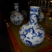 A pair of bulbous blue and white Chinese style vases with dragon relief