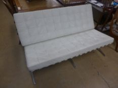A Barcelo design two seater bench with white leather cushions on chromium base