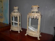A pair of distressed wrought iron lanterns