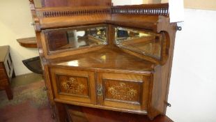 An Edwardian marquetry inlaid walnut hanging corner cupboard with pierced gallery and mirrored