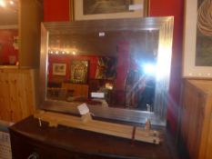 A rectangular silvered framed Art Deco style mirror having a bevelled plate 107 x 77 cm