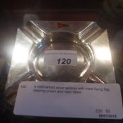 A hallmarked silver ashtray with inset flying flag bearing crown and harp detail