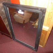 A modern mirror with rectangular plate in black painted frame