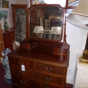 An Edwardian inlaid mahogany dressing chest the swing frame bevelled mirror above arrangement of