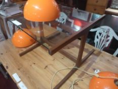 A Danish style low table the square glass top raised on teak supports