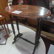 A Victorian inlaid walnut oval form occational table raised on turned supports and castors