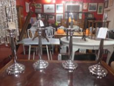 A set of four silver plated table lamps raised on circular bases
