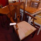 A Georgian elm elbow chair with drop in seat and raised on square section supports