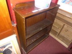 A walnut open bookcase on plinth base