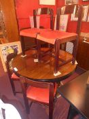 A designer rosewood dining table the circular top raised on four column base and the four matching