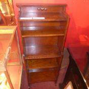 An oak open bookcase of narrow proportions
