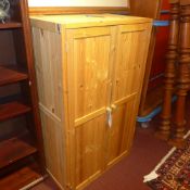 A contemporary pine side cabinet with pair of panel doors enclosing shelves