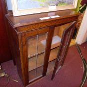 An oak bookcase with pair of leaded glazed panel doors enclosing shelves