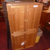 A pair of contemporary pine cabinets fitted pair of panel doors enclosing shelves