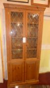 A pine side cabinet fitted pair of glazed panel doors above further pair of cupboard doors