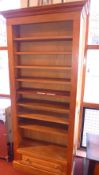 A pine open bookcase of narrow proportions and fitted single base drawer