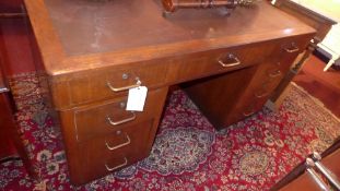 A 1960's teak pedestal desk the lined top above arrangement of drawers with metal handles