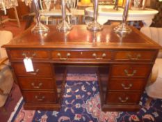 A Victorian mahogany pedestal desk the tooled leather top above arrangement of drawers with brass