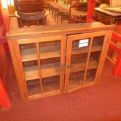 A bookcase section fitted pair of glazed panel doors