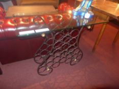 A wrought iron side table/wine rack with rectangular glass top
