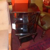 An Edwardian walnut revolving bookcase with pierced side panels and raised on cabriole supports
