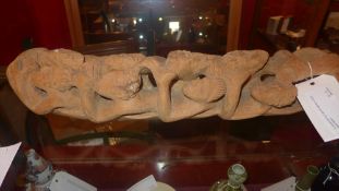 An African carving of several figures in a boat signed Nacius