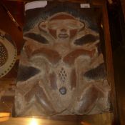 An African carved panel depicting a single seated figure