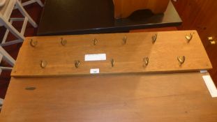 A set of brass oak mounted coat hooks