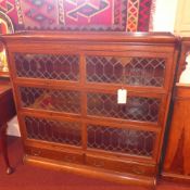 A C19th oak Globe Wernicke design three tier bookcase with leaded glazed panel doors and fitted
