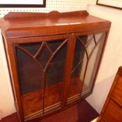 A mahogany display cabinet fitted two astragal galzed panel doors enclosing adjustable shelves on