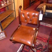 A mahogany swivel office chair with tan leather button back and leather seat with studded detail